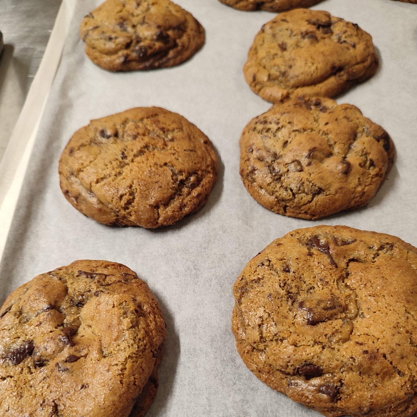 Baked cookies on a baking tray lined with parchment paper
